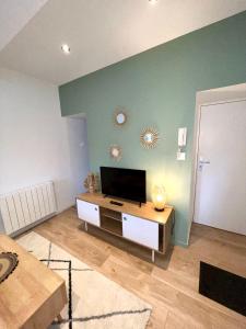 a living room with a flat screen tv on a wall at Appartement le Regnaudin in Moulins