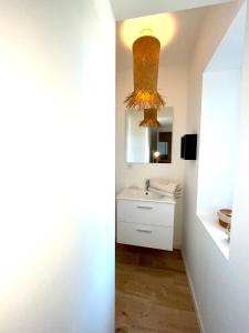 La salle de bains est pourvue d'un lavabo et d'un miroir. dans l'établissement Appartement le Regnaudin, à Moulins