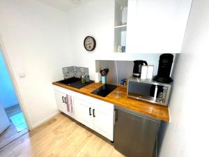 a kitchen with a counter top with a microwave at Appartement le Regnaudin in Moulins