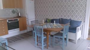 a kitchen with a wooden table with chairs and a dining room at Röda stugan in Hedemora