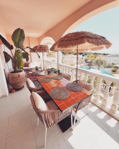 a dining room with a table with chairs and umbrellas at Luxueus appartement aan de Costa Blanca in Benissa