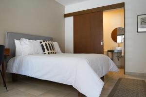 1 dormitorio con cama blanca y cabecero de madera en Casa Victorias en Guadalajara