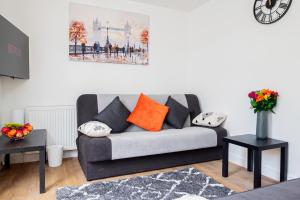 a living room with a gray couch with orange pillows at Wow 8beds 3bath Home Contractors Choice Parking in Basingstoke