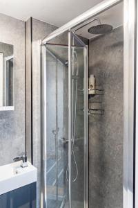 a glass shower in a bathroom with a sink at 8 Beds, 3baths Perfect For Contractors & Teams in Basingstoke