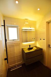 a bathroom with a sink and a window and a mirror at Radhus med bekvämt läge in Täby