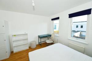 1 dormitorio con cama, escritorio y ventana en Radhus med bekvämt läge en Täby