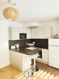 a kitchen with white cabinets and a table in it at Bright and fully renovated studio in Vanves in Vanves