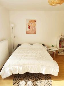 a bedroom with a white bed with a rug at Bright and fully renovated studio in Vanves in Vanves