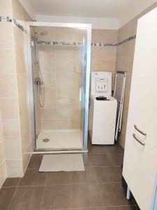 a bathroom with a shower and a washer and dryer at Bright and fully renovated studio in Vanves in Vanves