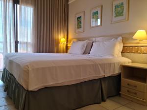 a hotel room with a large bed with white pillows at Jurerê Beach Village Studios Para Temporada in Florianópolis