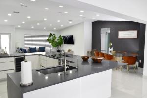 マイアミにあるLuxurious Home with BBQ, Hot Tub, Heated Pool & Wifi - L36のキッチン(シンク、カウンター、椅子付)