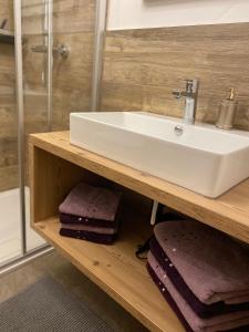 a bathroom with a sink and towels on a shelf at Sandi`s Ferienhaus in Reutte