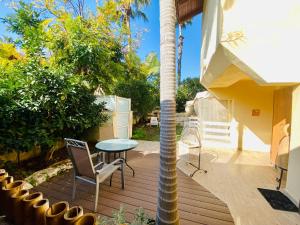 a porch with a table and chairs and a palm tree at Raanana Luxury Apartments in Ra‘ananna