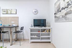Elle comprend un bureau blanc avec une télévision et une table. dans l'établissement Flatguest Arinaga Playa 4 Caracola, à Agüimes
