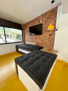 sala de estar con pared de ladrillo y cama en OPE Suites Usaquen, en Bogotá