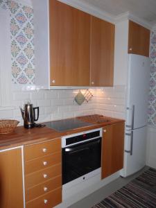 a kitchen with a stove and a refrigerator at Röda stugan in Hedemora