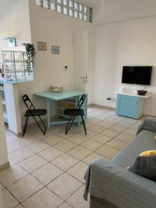 a living room with a blue table and chairs at Holiday Gels appartamento vacanze Ostia in Lido di Ostia