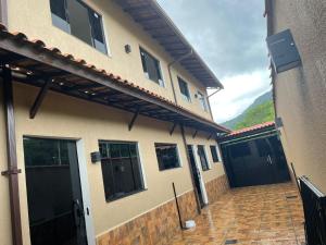 Casa Temporada , Parque mambucaba في انغرا دوس ريس: منزل بأبواب سوداء وممر من الطوب