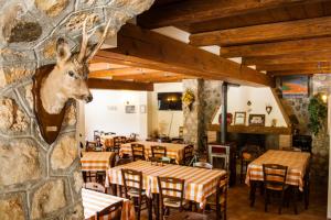um restaurante com mesas e uma cabeça de veado na parede em Al Peschio Pizzuto Agriturismo em Scanno