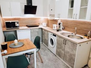 a kitchen with a sink and a table with chairs at wohnen wohlfühlen - Geräumiges Apartment in Forst in Forst