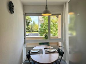 a table and chairs in a room with a window at Lumineux F2 / Pkg gratuit / proche A31 in Metz