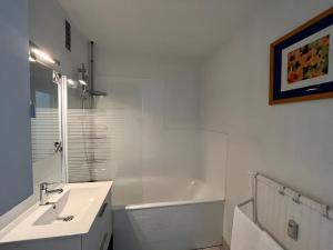 a white bathroom with a sink and a bath tub at Lumineux F2 / Pkg gratuit / proche A31 in Metz