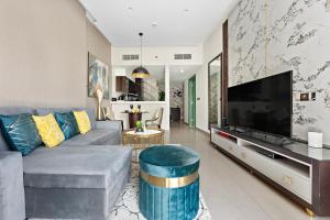 ein Wohnzimmer mit einem Sofa und einem großen TV in der Unterkunft Luxe 1BR sleeps 4, Near Burj Khalifa and Dubai Mall with Pool and free Parking in Dubai
