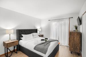 a bedroom with a large bed and a window at Hauts-bois Ski Inout 2brs Wpool Access 197-4 in Mont-Tremblant +26 photos