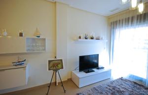 sala de estar con TV de pantalla plana y una pintura en Apartment De Jardines, en Denia
