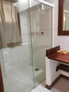 W łazience znajduje się prysznic ze szklanymi drzwiami. w obiekcie Le Jardin d'Éole - Pousada em Pontal de Maceio w mieście Fortim