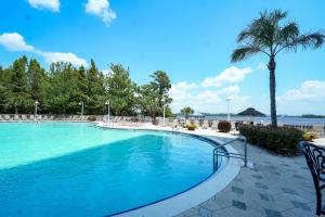 - une piscine dans un complexe avec un palmier dans l'établissement Renovated Condo Blue Heron 5 pax, à Orlando
