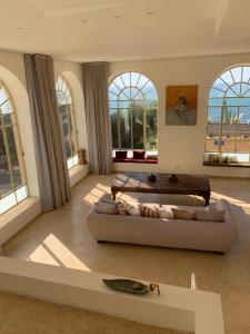 a large living room with a couch and windows at The Cliff Hotel. in Tel Aviv