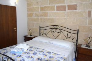 a bedroom with a bed and a brick wall at Casa Naida in Nardò
