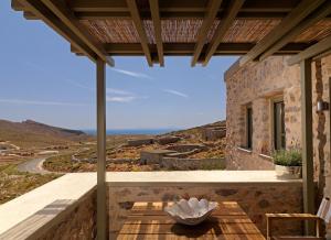 a patio with a table and a view of a mountain at Themonies Luxury Suites in Chora Folegandros
