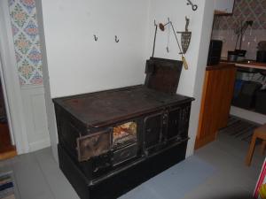 una antigua estufa de leña en una habitación en Röda stugan, en Hedemora