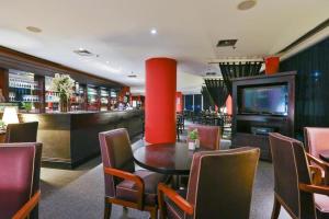 a restaurant with a table and chairs and a bar at Suite executiva reformada dentro do hotel Radisson in Sao Paulo