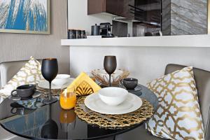a dining room table with chairs and a black table with glasses at Luxe 1BR sleeps 4, Near Burj Khalifa and Dubai Mall with Pool and free Parking in Dubai