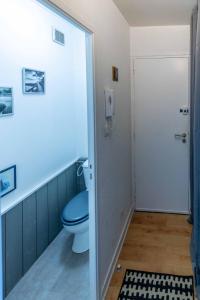 a bathroom with a blue toilet and a door at LE PRIEURE in Dinard