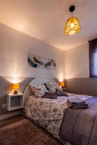 een slaapkamer met een bed en twee lampen en een licht bij LE PRIEURE in Dinard