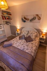 een slaapkamer met een bed met 2 lampen en 2 kussens bij LE PRIEURE in Dinard