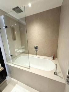 a bathroom with a tub with a glass shower at Luxury 2BR Apt at C House Near Buckingham Palace in London