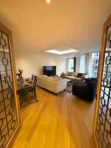 a living room with a couch and a table at Luxury 2BR Apt at C House Near Buckingham Palace in London