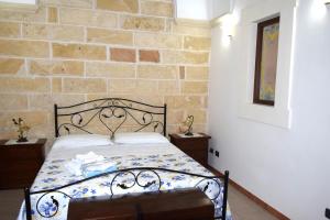 a bedroom with a bed with a stone wall at Casa Naida in Nardò