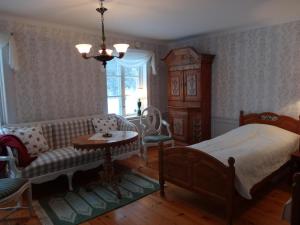 - une chambre avec un lit, un canapé et une table dans l'établissement Röda stugan, à Hedemora