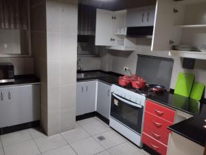 uma cozinha com armários brancos e um forno com placa de fogão em Hermoso departamento en La Paz-Bolivia em La Paz