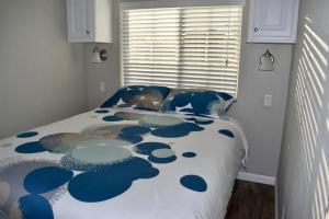 a bedroom with a bed with a blue and white comforter at Pinecraft Blue Heron Tiny Home in Sarasota