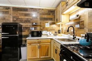 a kitchen with wooden cabinets and a black refrigerator at Leadville Motor Lodge in Leadville +8 photos