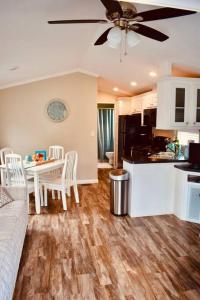 cocina y sala de estar con mesa y ventilador de techo en Pinecraft Blue Heron Tiny Home en Sarasota