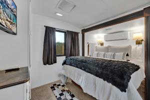 a bedroom with a large bed and a window at Lucinda Luxury RV with Hot Tub in Fredericksburg