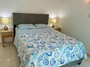 1 dormitorio con 1 cama con colcha azul y blanca en Villa del Carmen Boqueron en Cabo Rojo